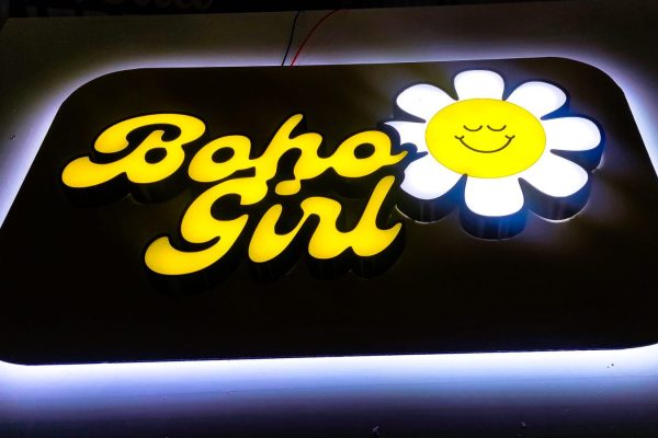 Firmă luminoasă Boho Girl cu litere galbene și iluminare în halou